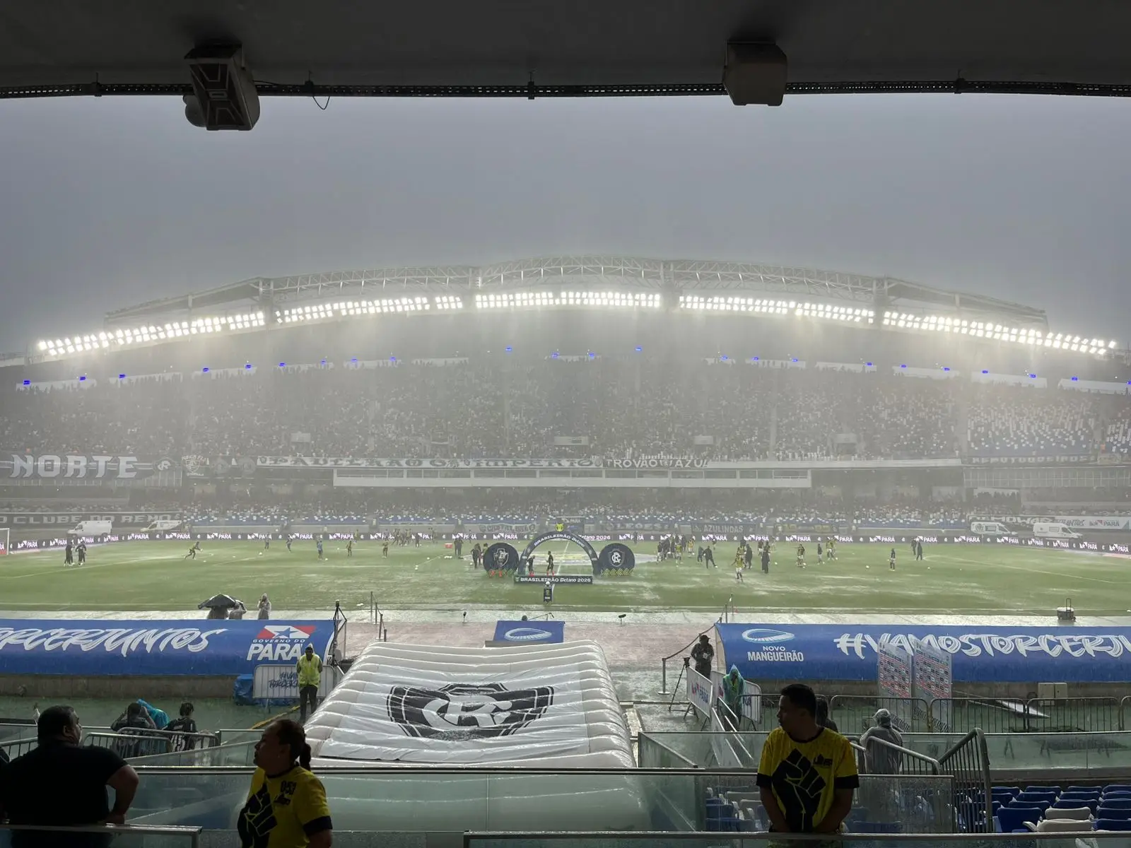 Dilúvio no gramado. A arbitragem faz testes para avaliar as condições de jogo, mas o campo já apresenta pontos encharcados e a bola mal consegue rolar. Há risco de adiamento do início do jogo.